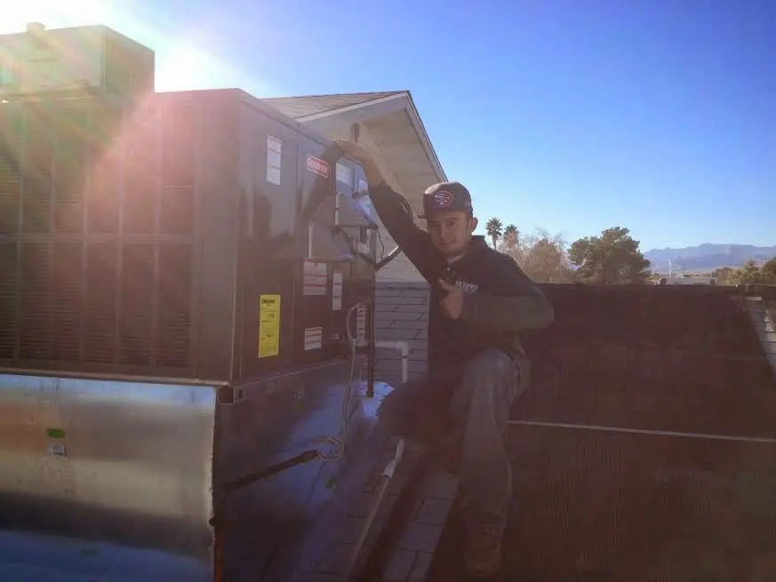 HVAC technician performing Air Duct Cleaning on a rooftop unit in Orange